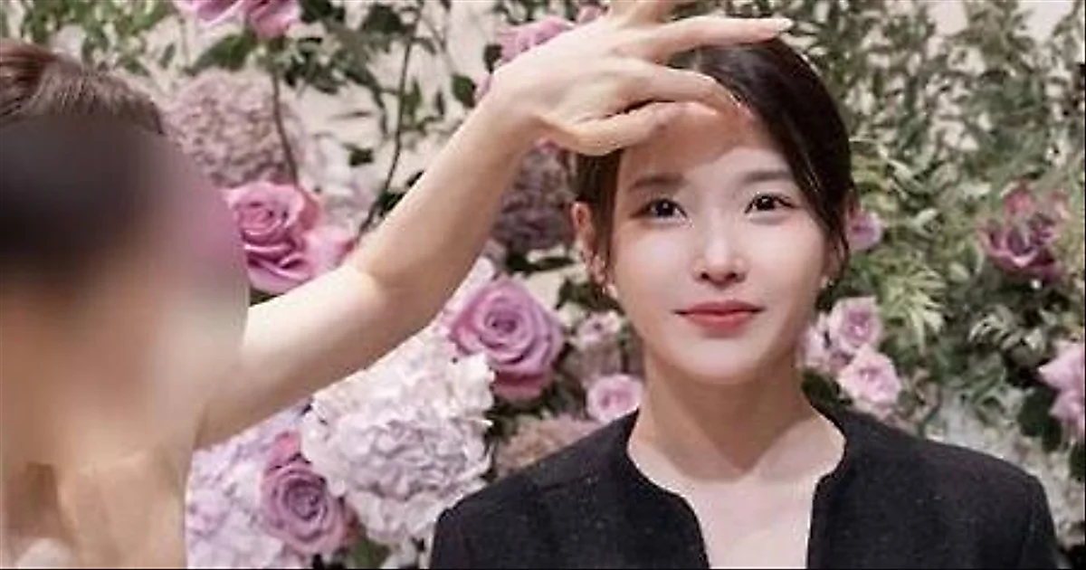 Bride fixes IU's hair at wedding, showcasing 10-year bond
