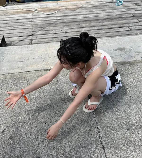 aespa Karina walks on the beach in a red beach look with a baby piglet