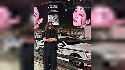 Shinsegae heiress ANNIE poses by massive billboard featuring her music video